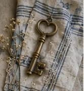 Brass skeleton key resting on striped linen